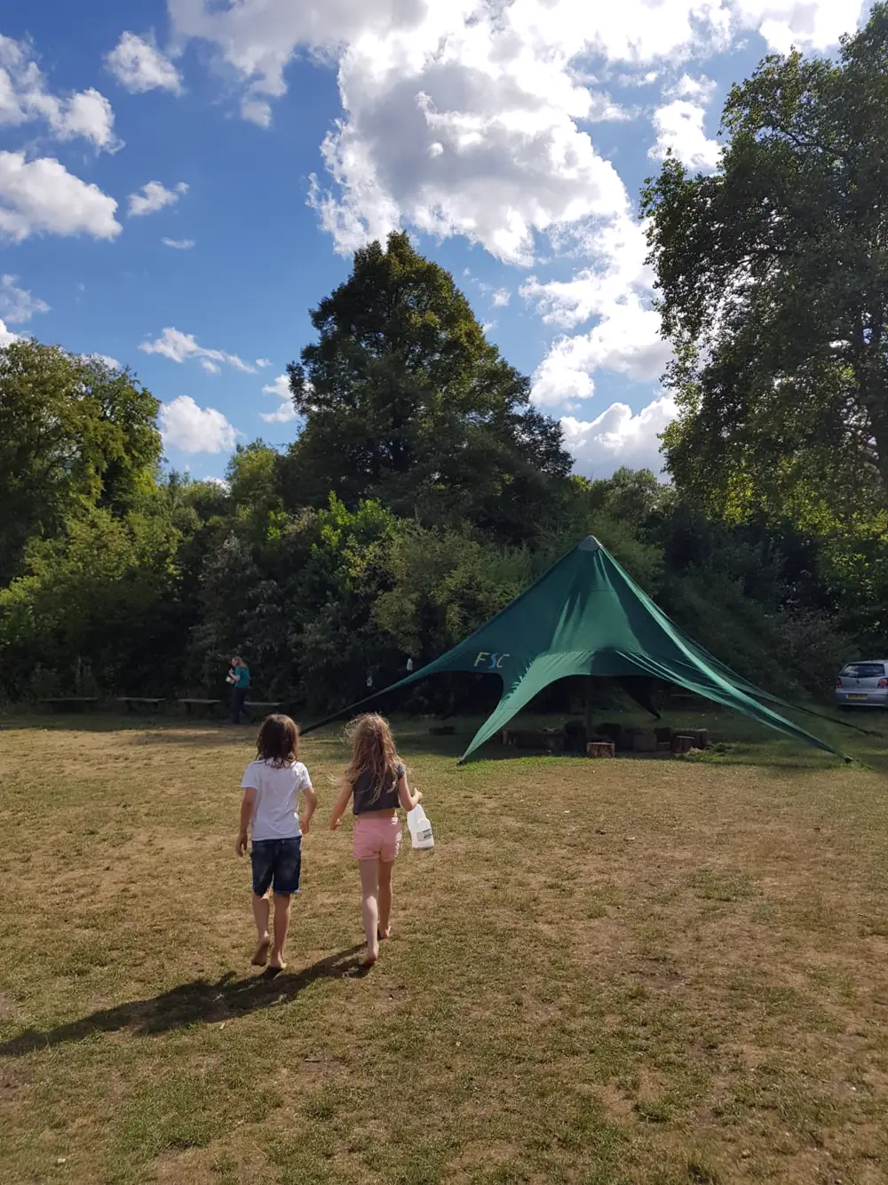 Walking across the field towards the study centre tent on a bright day
